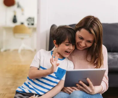 A mother and child talking to a speech therapist on their iPAD to get speech help